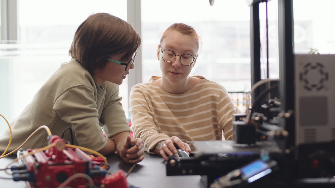 Teacher and Schoolboy Using Computer during Lesson