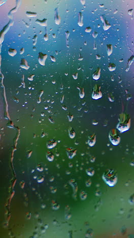 drops of rain on window glass on blur background. rainy weather. rain droplets flowing down on glass window at rainy day. close-up. vertical video