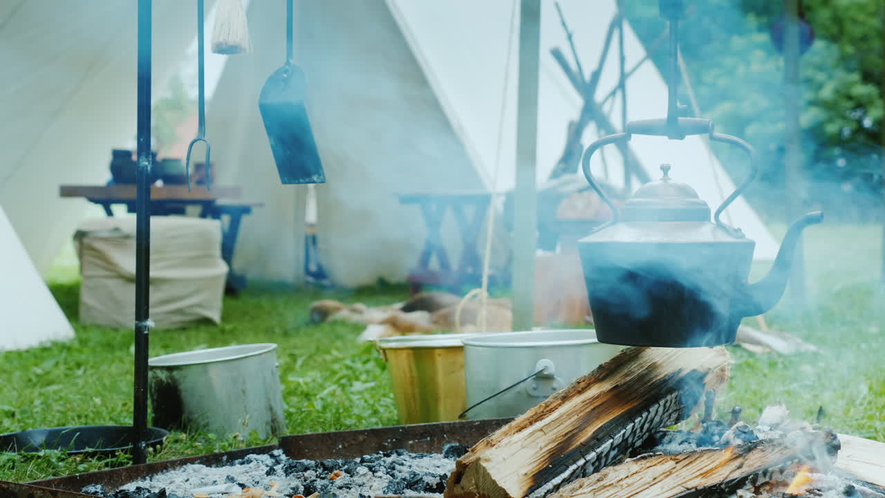 숲 음식에 있는 아메리카 원주민 캠프가 전경 전통 wigwam 텐트에서 준비되고 있습니다.