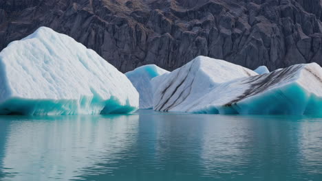 icebergs floating in a glacial lagoon with mountains in the background