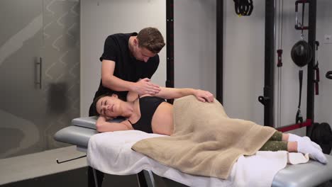 physiotherapist checking up arm of woman in clinic