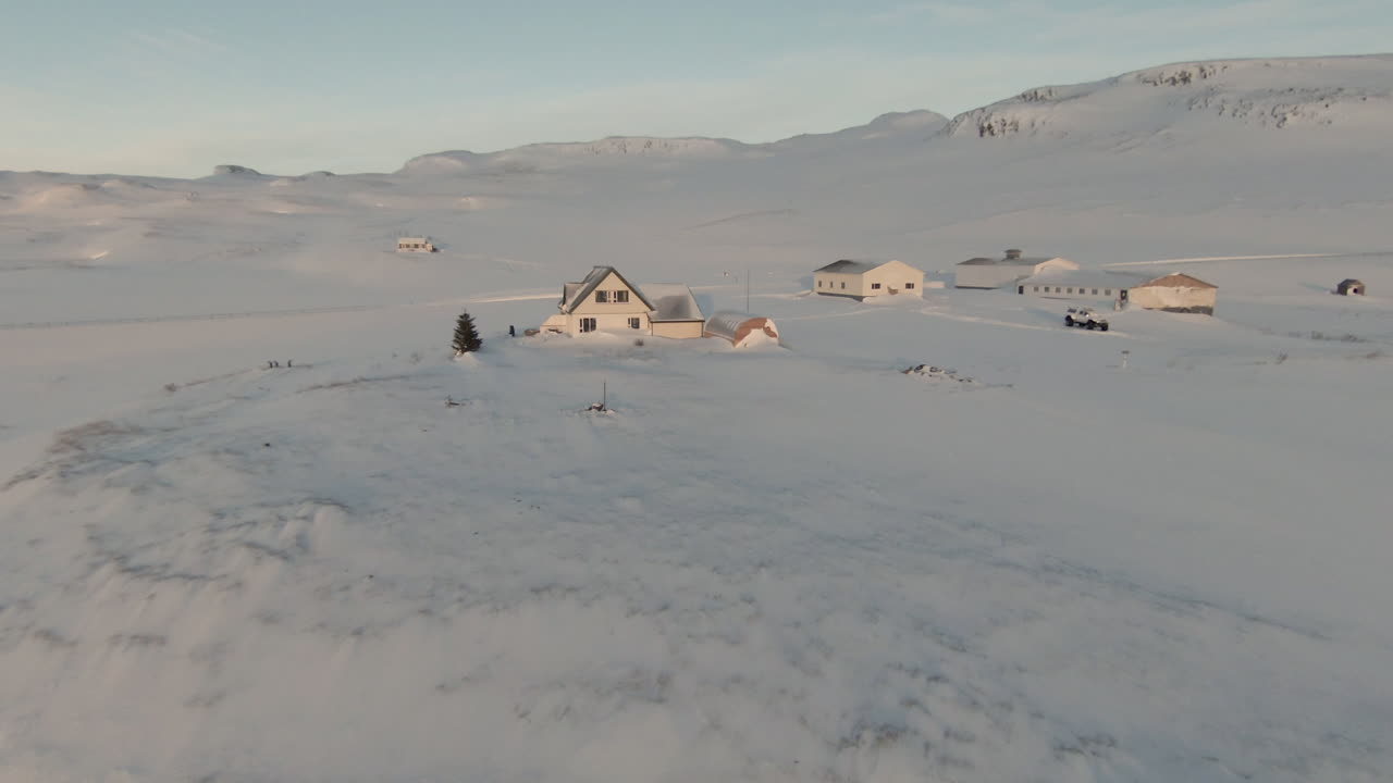 Icelandic farm by fjord covered in snow, mountain background