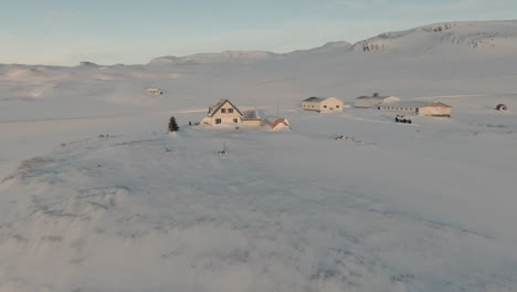 icelandic farm by fjord covered in snow, mountain background