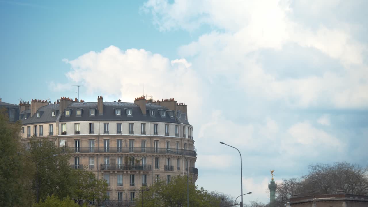 edificio de apartamentos de parís con nubes blancas esponjosas que se mueven lentamente detrás, vista estática