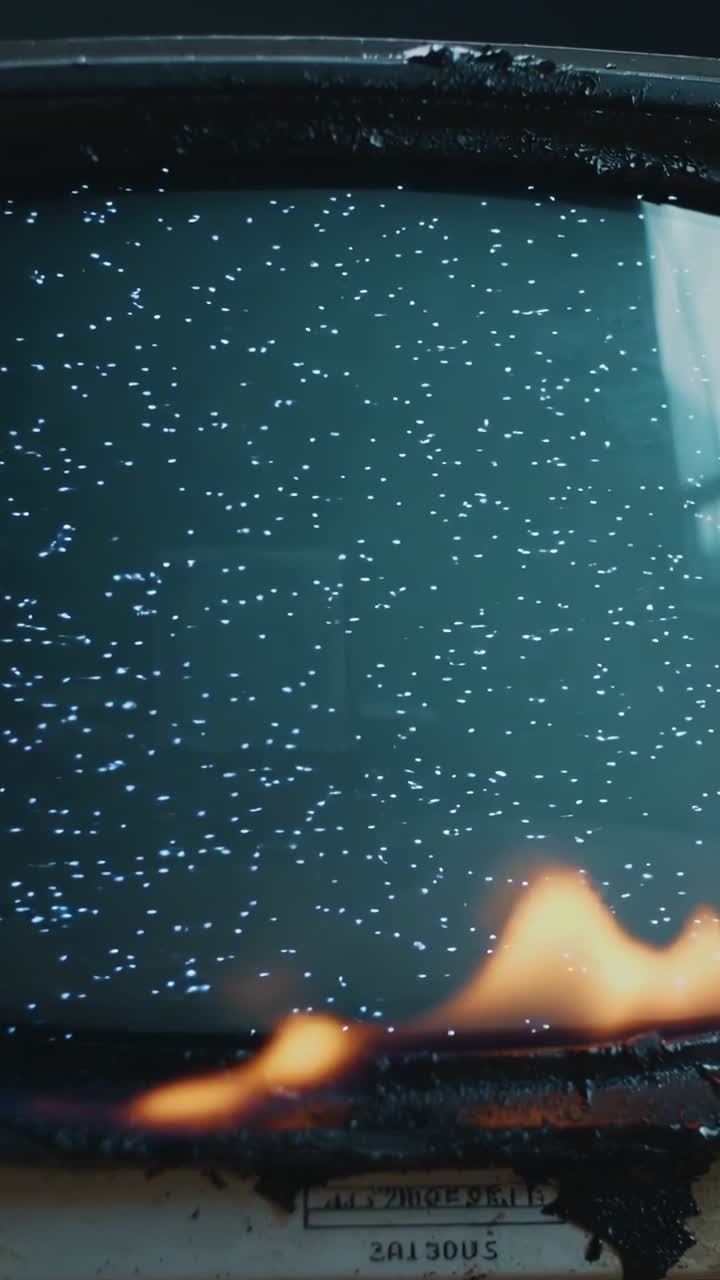 Vertical video: Sparking lower bezel causing CRT monitor flickering static as flames rise then fall