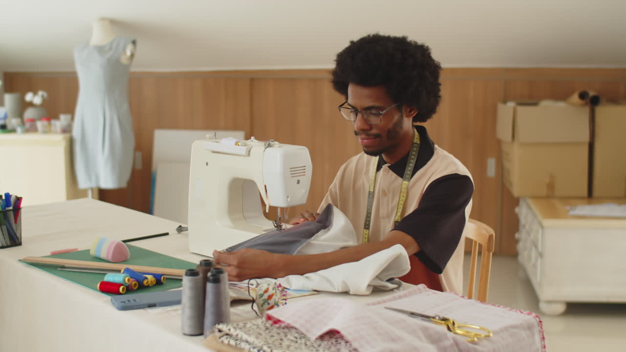 Afro-américaine cousant un t-shirt sur une machine à coudre