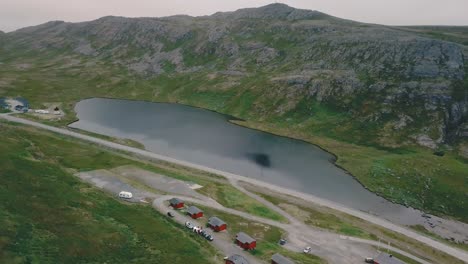 Elevando-Mientras-Se-Mueve-Hacia-Los-Lados,-Un-Dron-Disparó-Junto-A-Un-Lago-Y-Un-Campamento