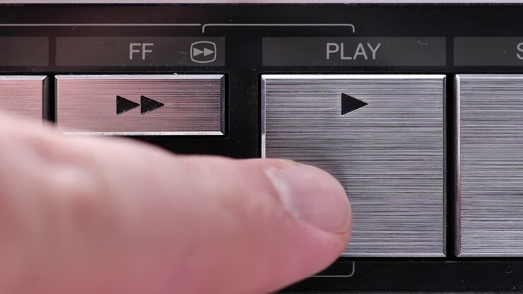 Primo piano estremo dei pulsanti di un vecchio videoregistratore antico o vintage, con il pulsante Play premuto