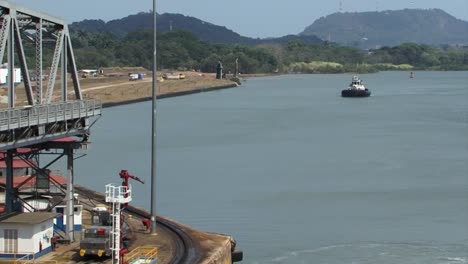 tugboat waiting for the ship to exit the last chamber of miraflores locks, panama canal