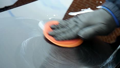 polishing a black car by hand