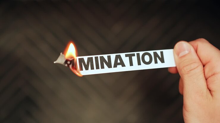 Close-up of a hand holding a paper label reading “RUMINATION” as the edge burns in flame, symbolizing anxiety, overthinking, and letting go