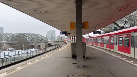 Red-S-Bahn-drives-in-Cologne-from-the-main-station-from-an-empty-train-station-over-towards-the-bridge