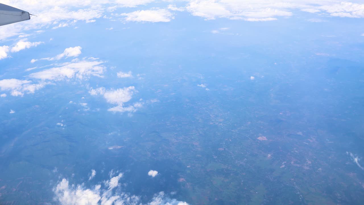 飛行機の窓から見た雲と景色