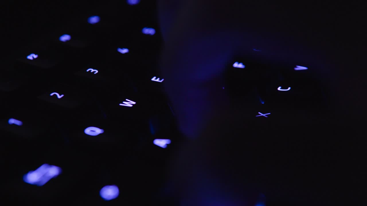 Colorful backlit Gaming Keyboard Typing and Writing Close Up with illuminated vivid color shift