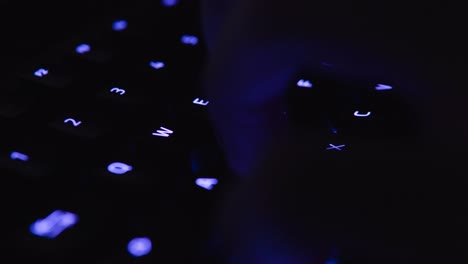 colorful backlit gaming keyboard typing and writing close up with illuminated vivid color shift