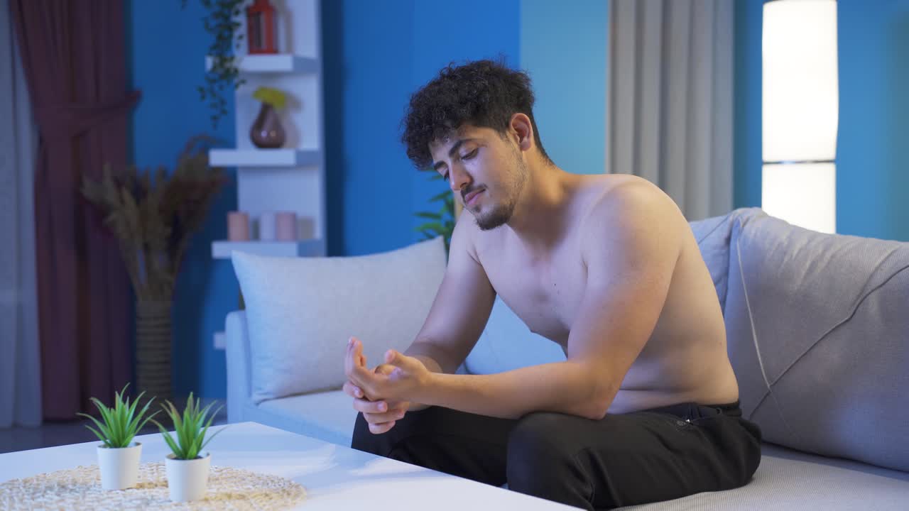Young man feeling happy and positive at home at night.