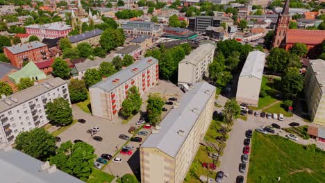 drone moves left over renovated soviet-era house, liepāja, latvia, market square