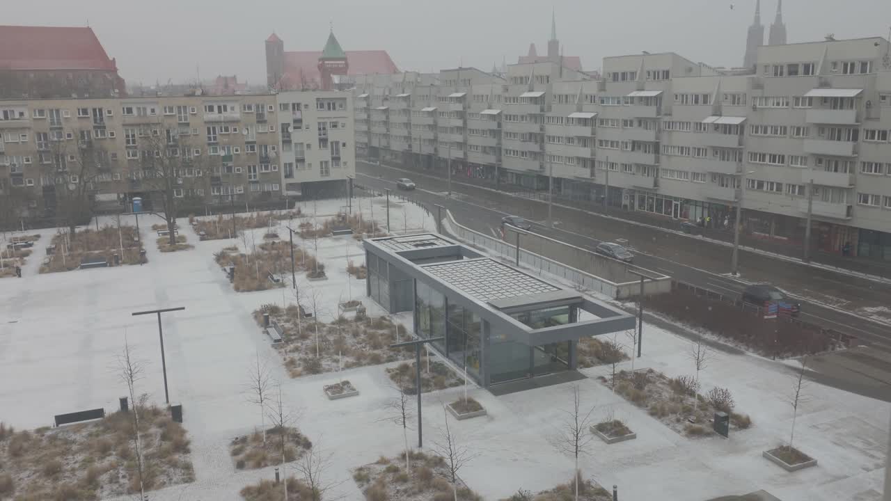 Langsom trafik på Nowy Targ-pladsen i Wroclaw, dækket af sne under snefald