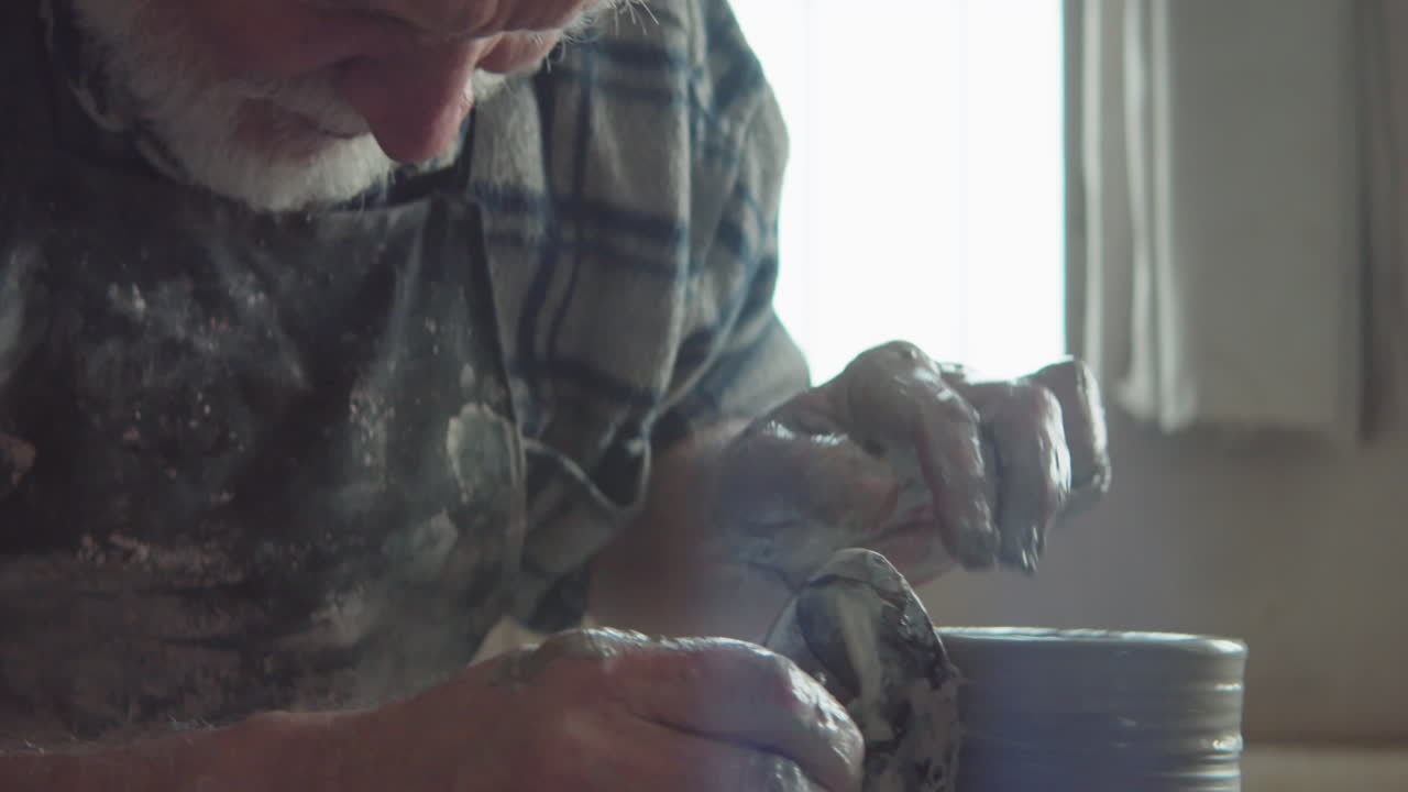Elderly Potter Throwing Vase on Wheel