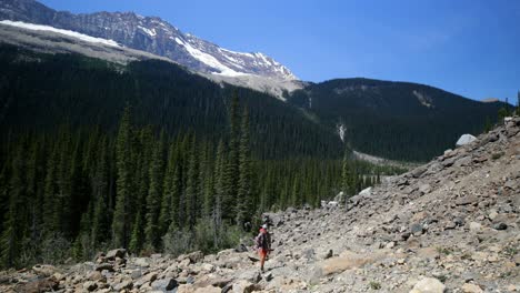 Front-view-of-young-caucasian-male-hiker-with-backpack-hiking-on-mountain-4k