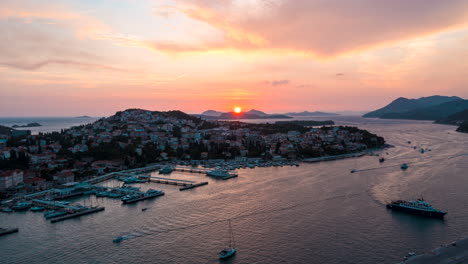 aerial hyperlapse of the sun setting over an active coastal port in dubrovnik, croatia