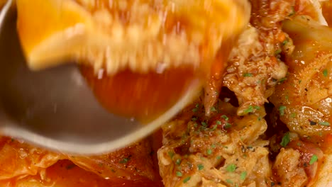 foto macro de una cuchara tomando un trozo de comida tradicional española callos