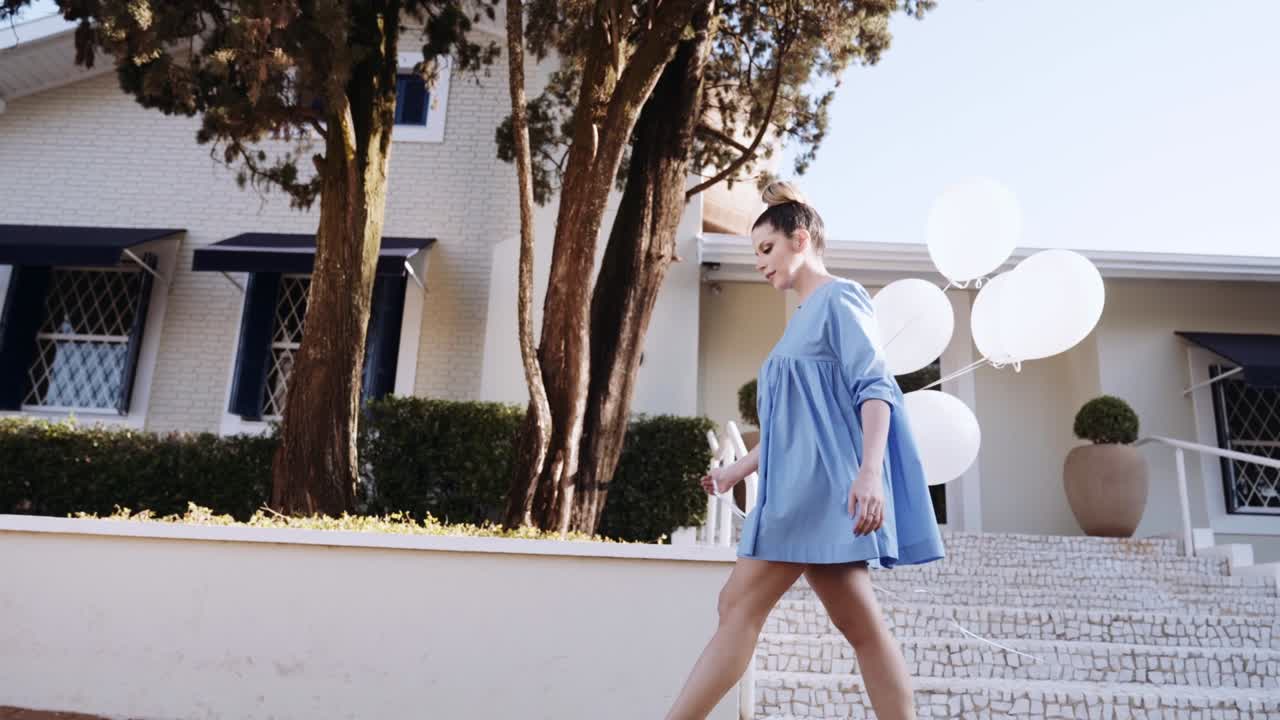 행복한 아름다운 라틴 여성이 도시를 고 있습니다. 젊은 금발 소녀는 느린 동작으로 하루를 즐기고 있습니다. 풍선과 함께 도시에서 습니다.