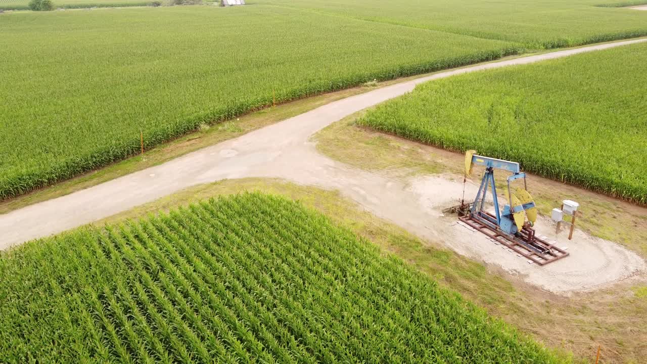 Aerial View Of Oil Pump In A Corn Field In Isabella County, Michigan - drone shot