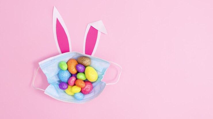 Easter eggs in creative face mask with bunny ears. Stop motion flat lay