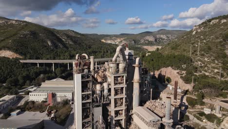 vistas aéreas de una fábrica de cemento cerca de la costa de barcelona con una autopista detrás con tráfico