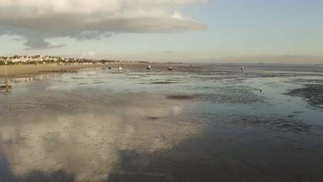 Fly-over-a-warming-Southend-coastline-with-low-tide-and-water-reflections