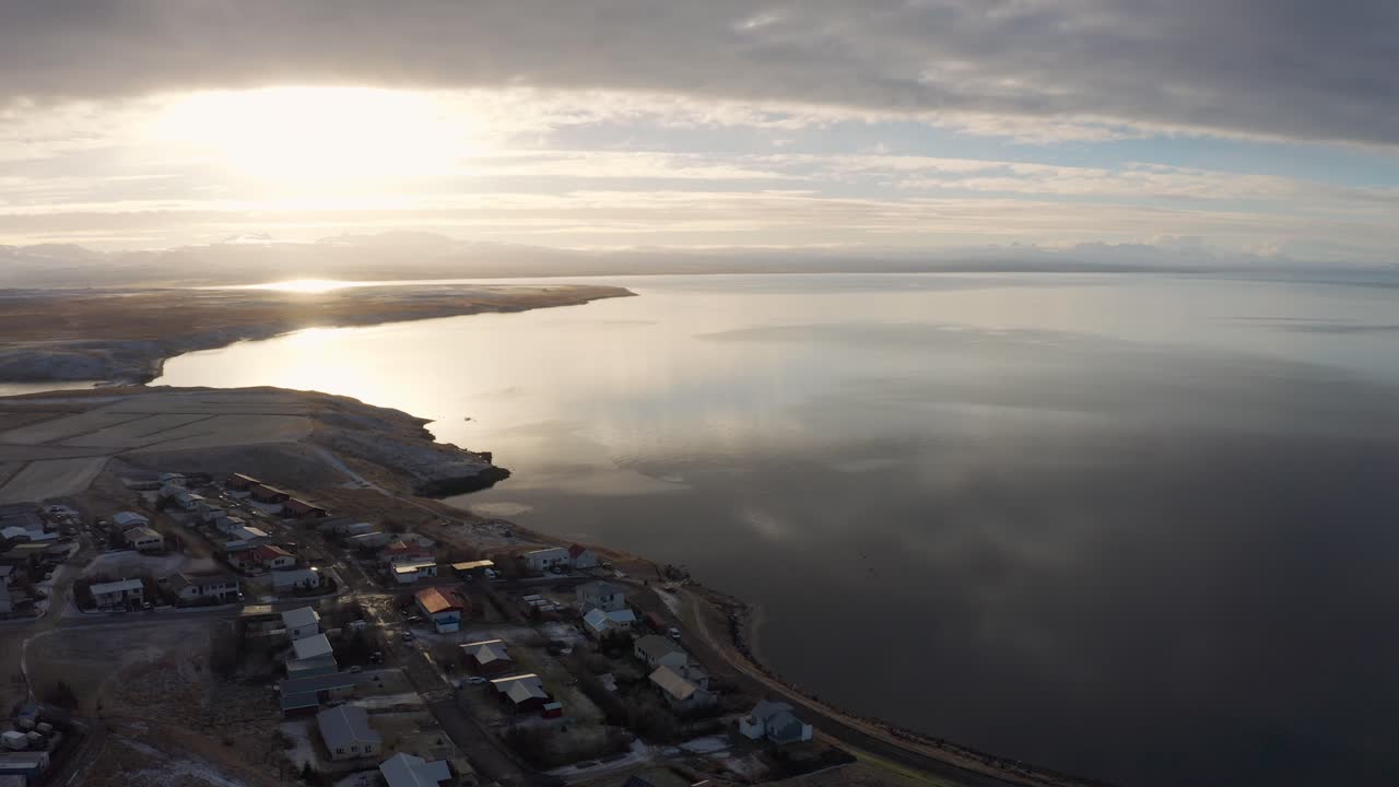 Küstenlinie von Reykjavík bei einem strahlenden Sonnenuntergang, der sich im kalten isländischen Ozean spiegelt, Luftaufnahme mit einer Drohne in der Nähe von Borgarnes, Island