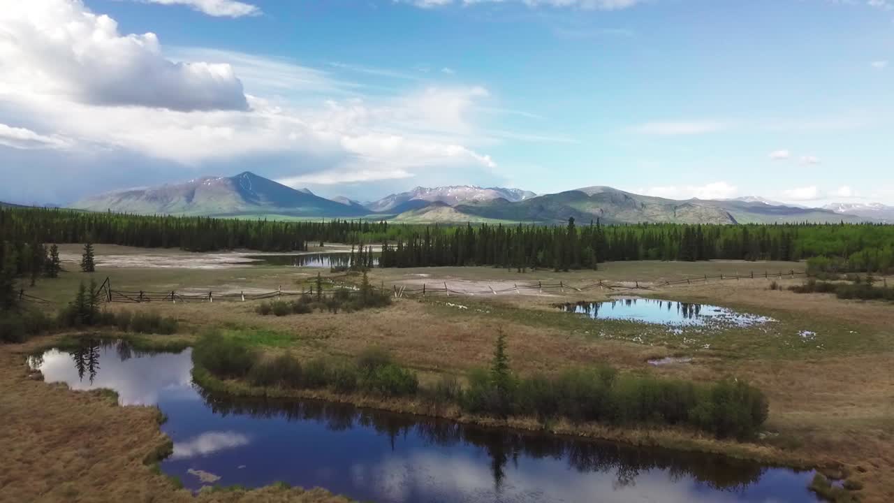 espectacular escena panorámica de la naturaleza del paisaje al aire libre del yukón y vuelo sobre el lago del espejo, gran cielo azul expansivo y cordillera en el fondo, caballo blanco, canadá, enfoque aéreo superior