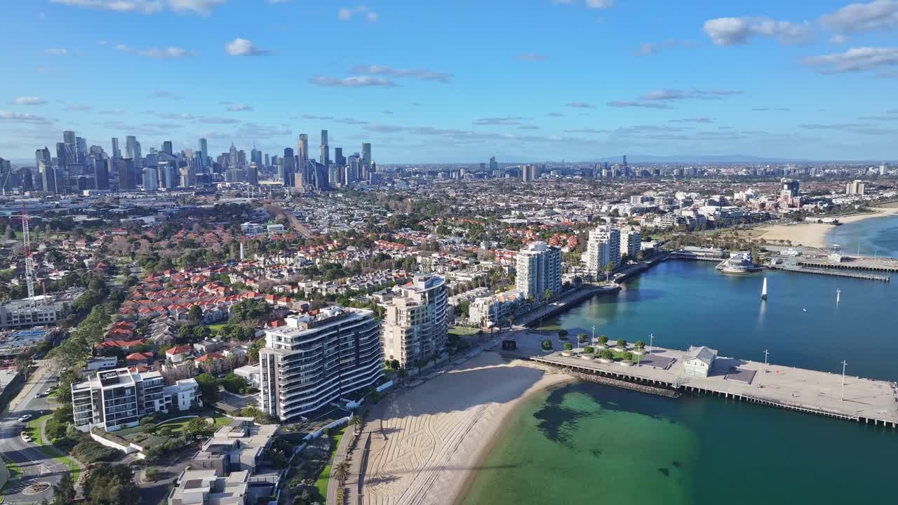 Aerial view of Port Melbourne waterfront promenade and beach with Melbourne city skyline in background