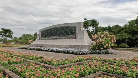 time-lapse of flowers blooming around a monument.