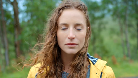mujer con impermeable amarillo en el bosque