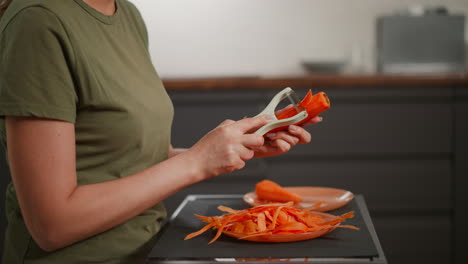 woman peeling and shredding carrots
