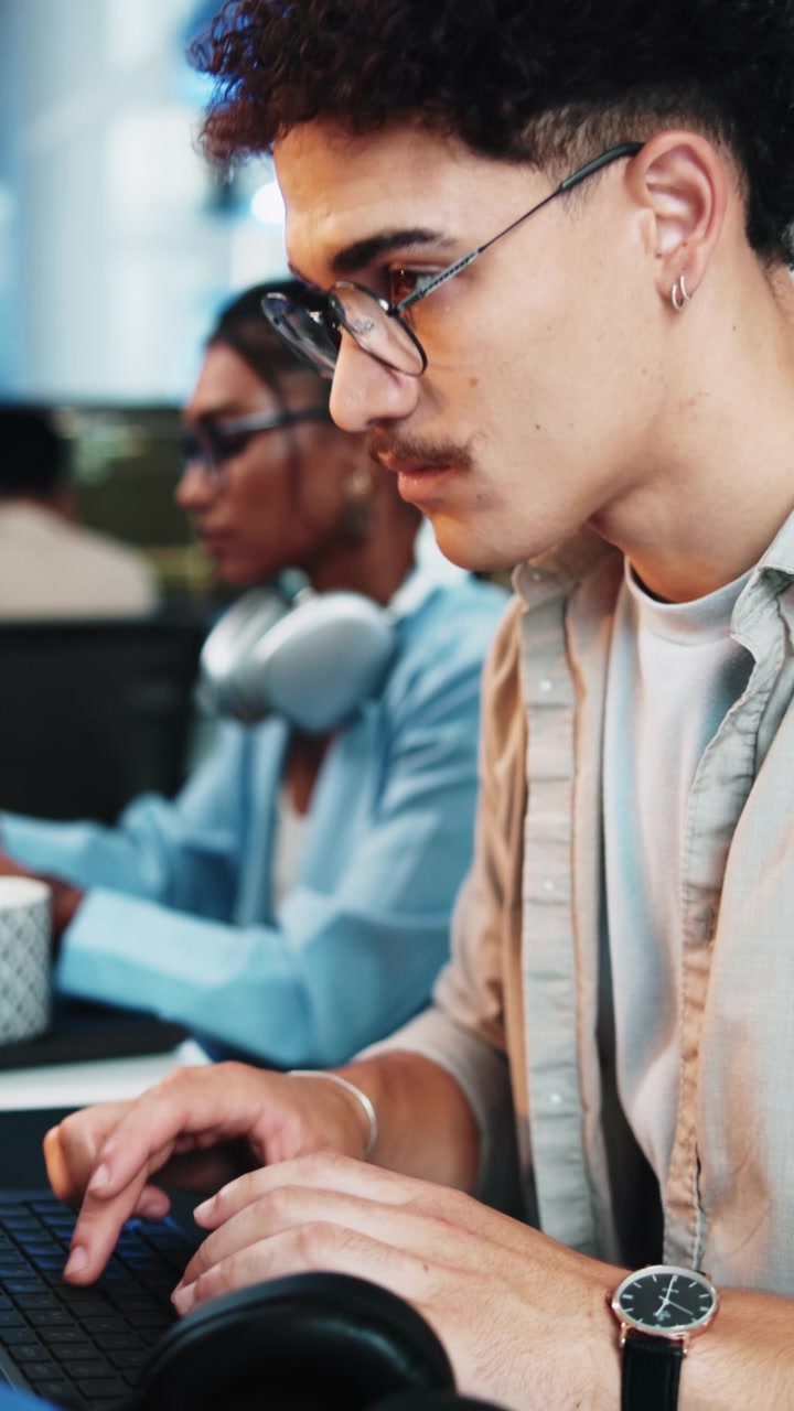 Young Man Working on Laptop in Modern Office