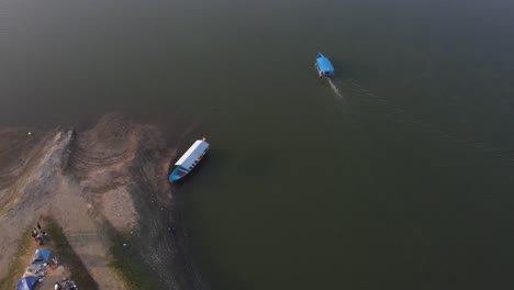 Luftaufnahme,-Blaue-Boote-Fahren-Reibungslos-Auf-Dem-Sermo-Stausee-Mit-Ruhigen-Strömungen