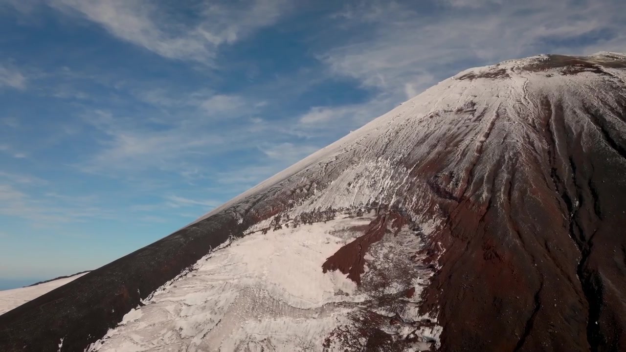 Filmato del Vulcano Avachinsky con chiazze di neve sui pendii di cenere vulcanica nera sotto un cielo nuvoloso nel Territorio della Kamchatka, Russia, un drammatico paesaggio selvaggio.
