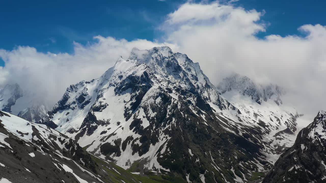 vuelo aéreo a través de nubes montañosas sobre hermosos picos nevados de montañas y glaciares.