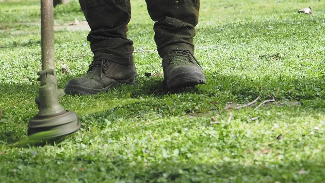 Man mowing grass with a string trimmer