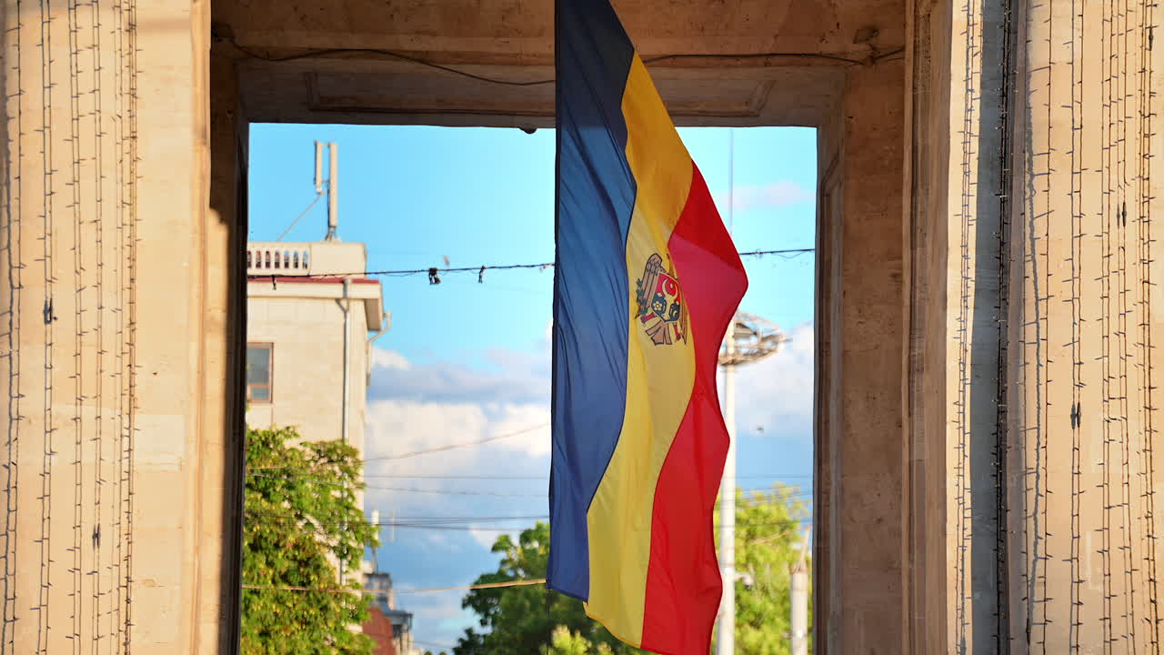 Close view of a waving in the wind national flag located under the Triumphal Arch in Chisinau, Moldova