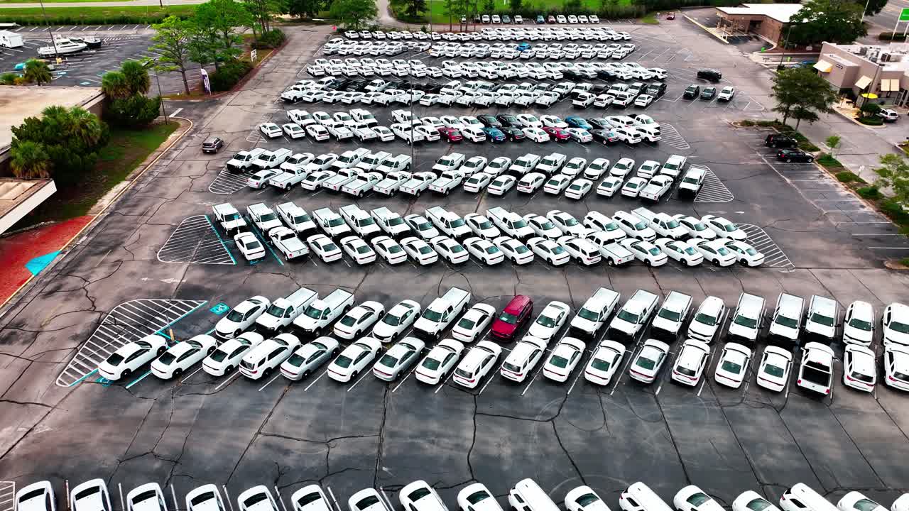 검은색,  ⁇ 색, 은색 차량으로 가득 찬 주차장 위에서 낮게 날아다니고 있습니다.