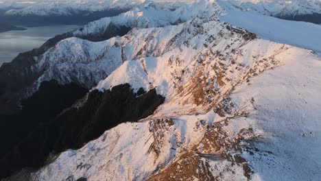 Drone-Sobrevolando-La-Cordillera-Cubierta-De-Nieve,-Abriéndose-A-La-Vista-Alpina