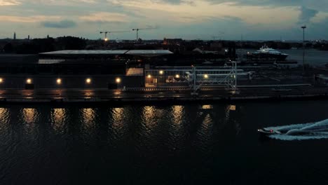 toma en cámara lenta de la guardia costera acelerando a través del puerto al atardecer