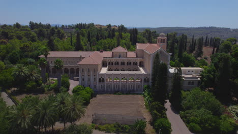 Monastery-of-the-Silent-Monks,-Latrun---located-at-the-top-of-the-hill-in-Ayalon-Valley,-the-monks-lifestyle-based-on-simplicity-and-harmony-with-nature---tilt-up-reveal-shot