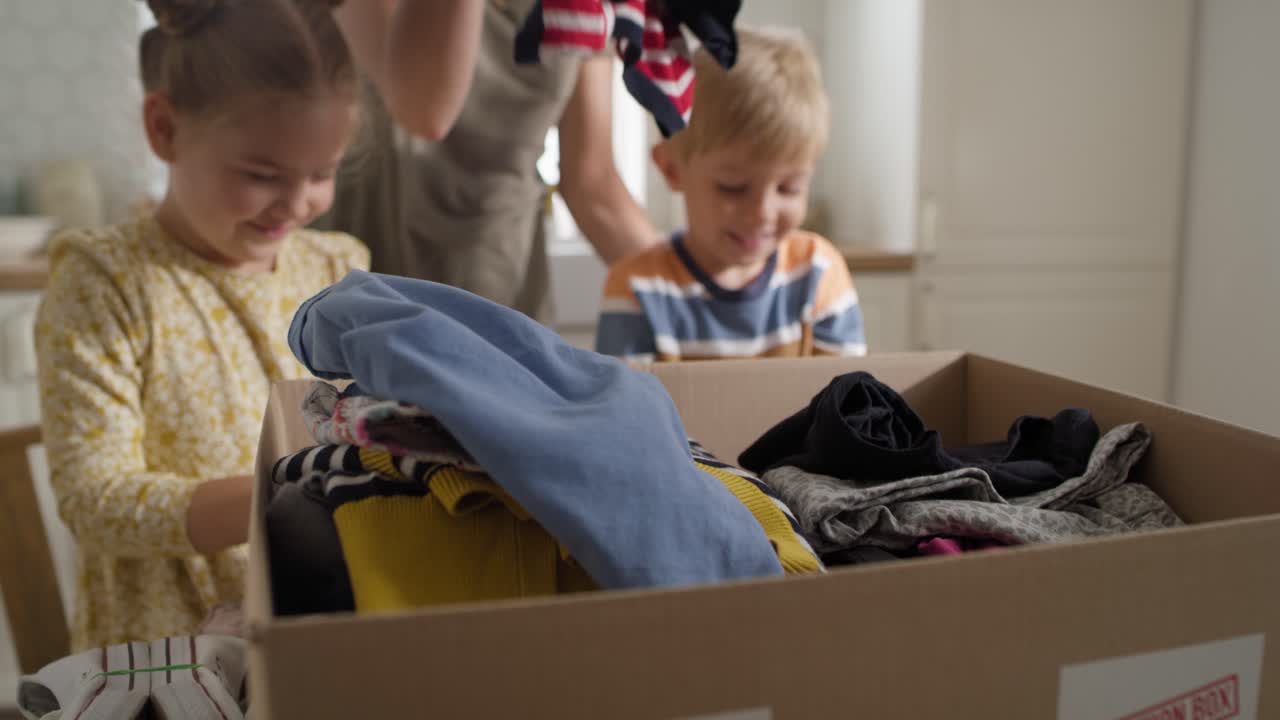 Close up video of children sorting clothes for donation