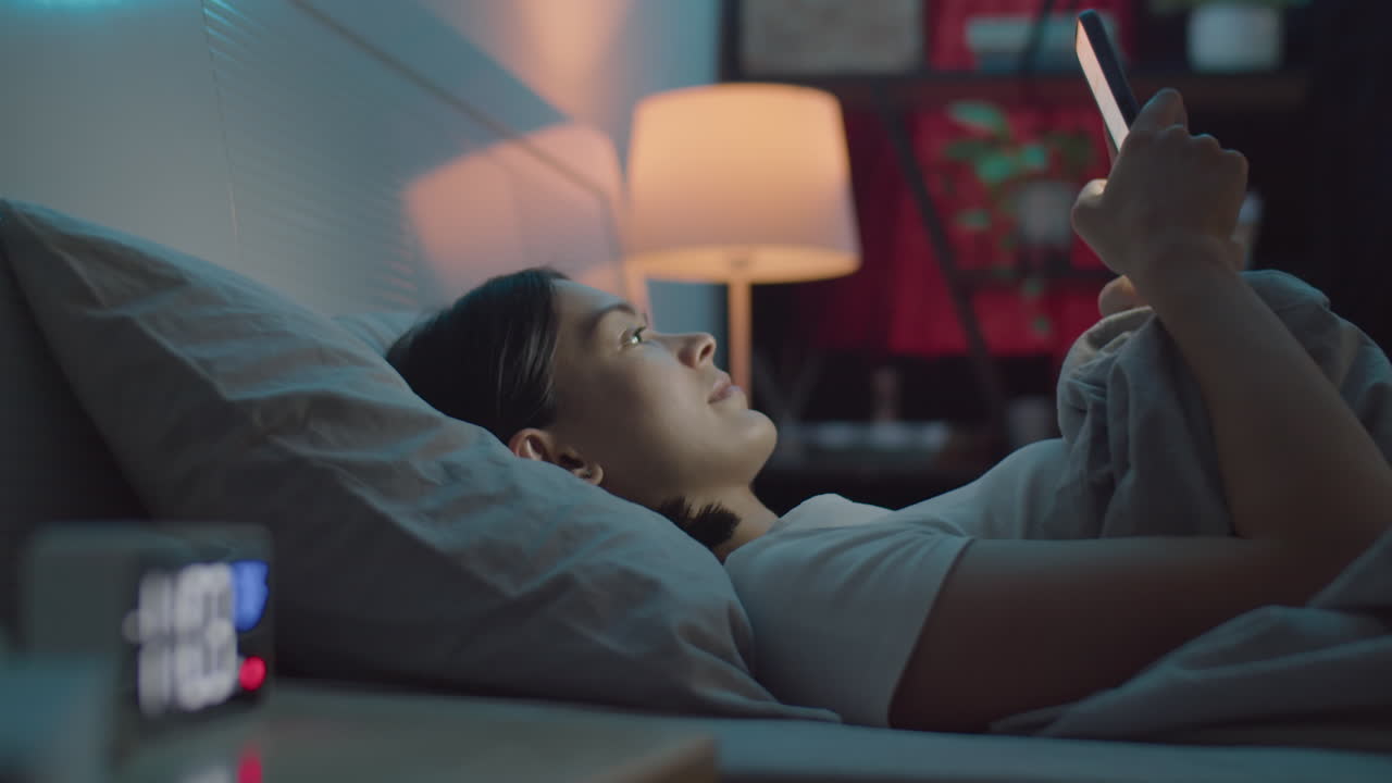 Woman Messaging on Phone in Bed at Night