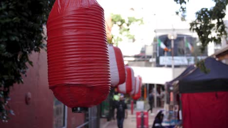 Linternas-De-Papel-Chinas-Que-Se-Balancean-Con-El-Viento-Con-Una-Feria-Callejera-Debajo